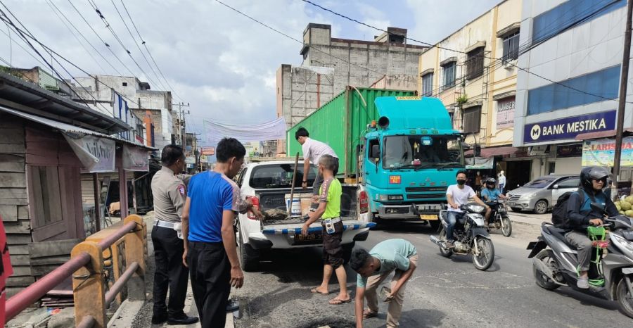 Unit Lantas Polsek Kualuh Hulu Perbaiki Jalan Berlubang di Jalinsum Jenderal Sudirman